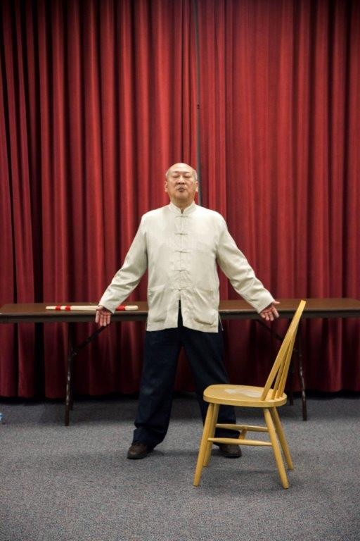 Master Victor Chiang behind a chair